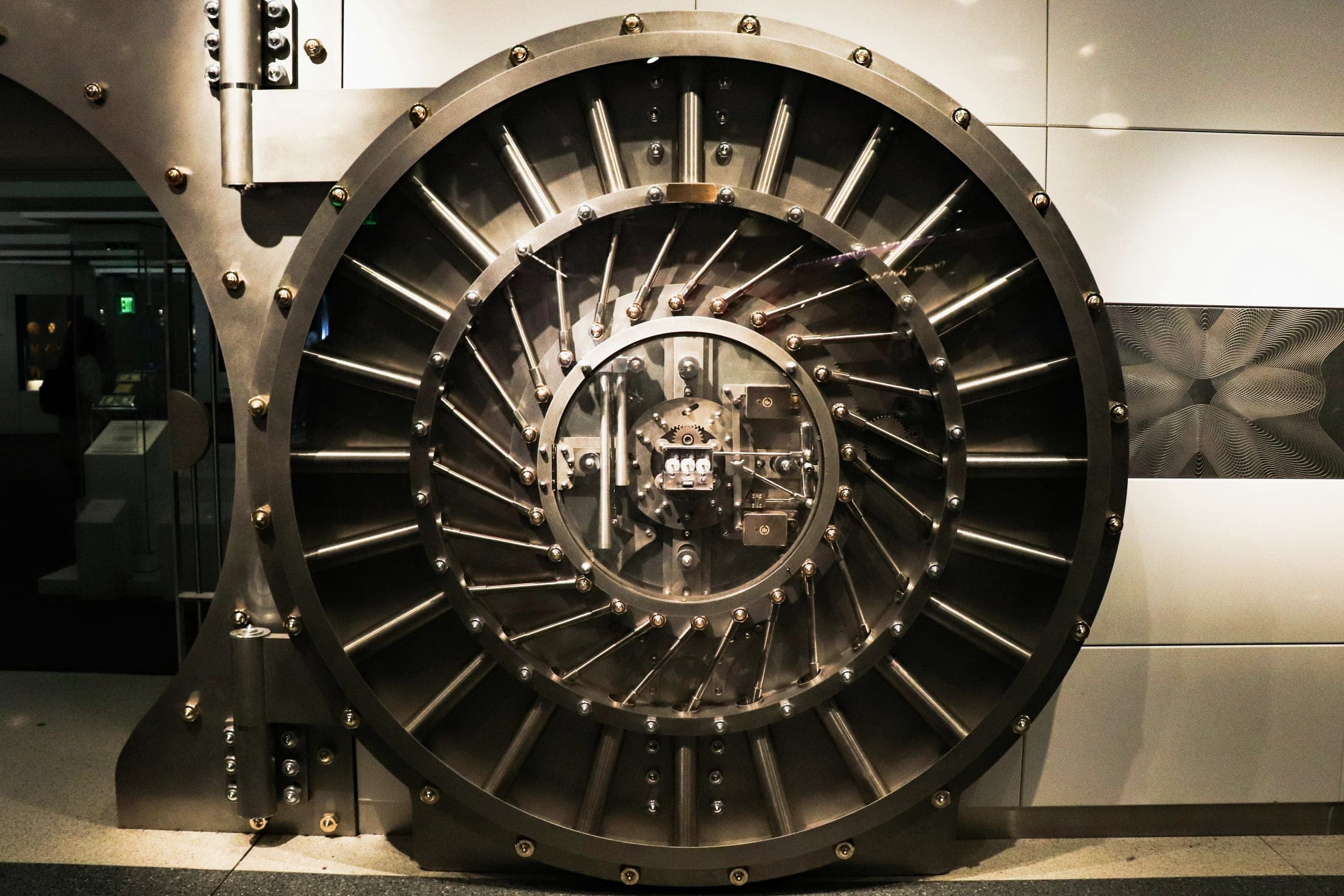 A large circular steel bank vault door with radiating bolts and a central locking mechanism.