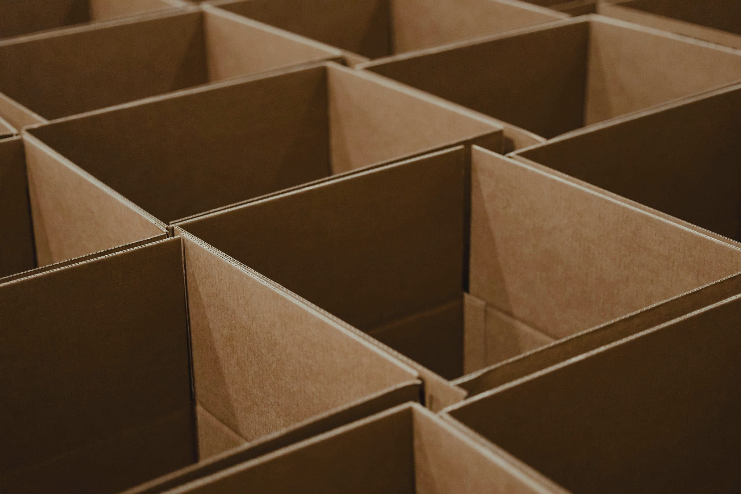 Rows of open corrugated cardboard boxes seen from above at an angle.